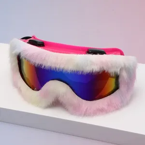 Close-up of ski goggles with a mirrored rainbow lens and fluffy white-pink trim on a pink frame