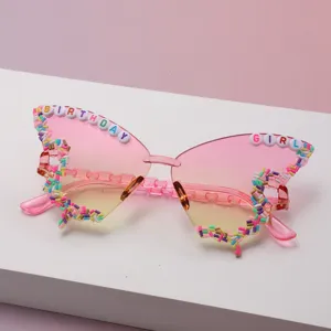 Close-up of pink butterfly sunglasses, gradient lenses and colorful Birthday Girl beads