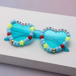 Close-up of turquoise party sunglasses with colorful beads and MERRY CHRISTMAS lettering