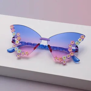 Detailansicht der blau-pink verlaufenden Schmetterlingsgläser mit bunten Blumenverzierungen am Rand