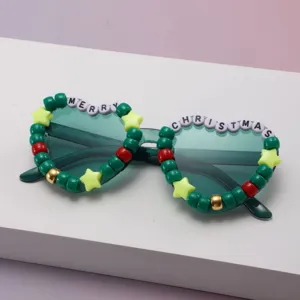 Close-up of green gradient lenses framed by festive beads spelling “MERRY CHRISTMAS”