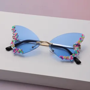 Vue détaillée de verres bleus dégradés en forme papillon, ornés de détails colorés et d'un pont métallique fin