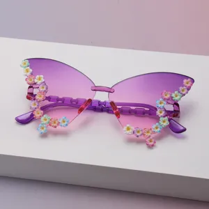 Detailansicht einer randlosen Schmetterlingssonnenbrille mit violettem Verlauf und bunten 3D-Blüten