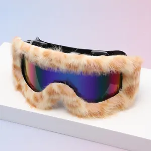 Close-up of ski goggles with leopard-print faux-fur trim, a black frame, and iridescent lenses