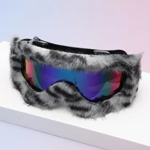 Goggles displayed on a white surface, with gray-black faux-fur trim and a blue-purple mirrored lens
