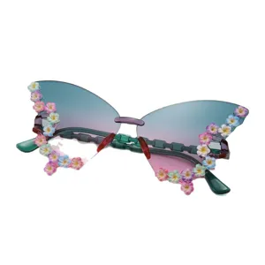 Rahmenlose Schmetterlingssonnenbrille mit türkis-rosa Verlaufsgläsern und bunten 3D-Blüten