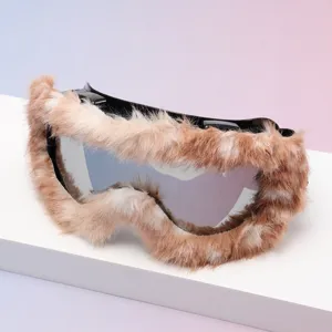 Close-up of silver mirrored ski goggles with a black frame trimmed in brown and cream faux fur