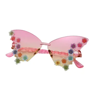 Rimless butterfly sunglasses with pink-to-yellow gradient lenses and colorful flower accents