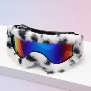 Close-up of white-and-black spotted faux-fur trim framing a reflective rainbow-mirror goggle lens