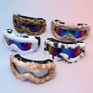 Five goggles with mirrored lenses and varied faux-fur frames arranged on a pastel background