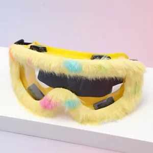 Close-up of yellow goggles with multicolored fluffy trim, clear lenses, and a black elastic strap