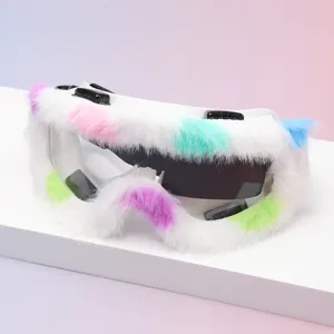 Close-up of white goggles with fluffy trim in pink, teal, purple and blue, shown at an angle
