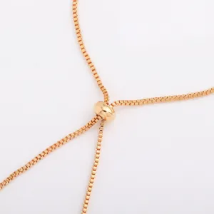 Close-up of a gold-tone box chain with a rounded sliding clasp and adjustable strands on white