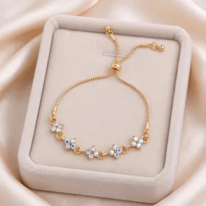 Gold-tone bracelet with five colorful flower stones, displayed in a cream velvet jewelry box