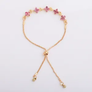 Gold-tone chain bracelet with pink flower charms, an adjustable slider clasp and bead-ended tails