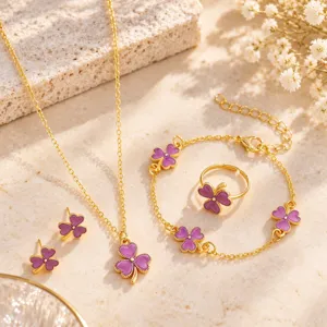 Purple four-leaf clover charms with gold-tone chains, arranged as a matching jewelry set