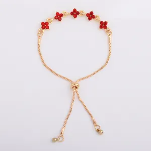 Detail showing five red rhinestone flowers, gold links, and adjustable sliding clasp on a bracelet