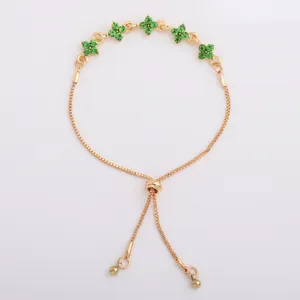 Flat lay of a gold-tone chain with five green flower-shaped stones and an adjustable slider clasp