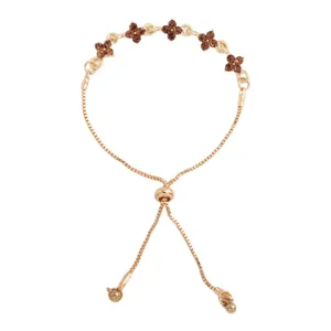 Gold-tone adjustable bracelet with brown rhinestone clover flowers, shown flat on a white background