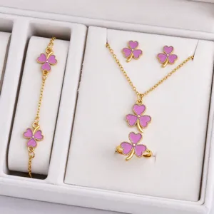 Gold-tone jewelry set in a white display box, with purple enamel clover charms and chains.