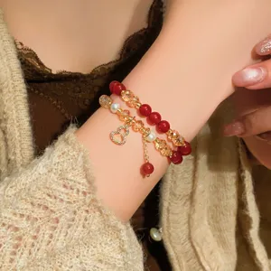 Bracciale a doppio giro al polso, con perle rosse, cristalli color champagne e ciondolo a cuore