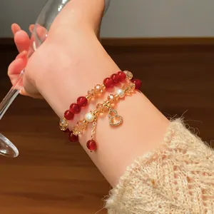Polso con perline rosse, cristalli sfaccettati, perle e ciondolo dorato a forma di zucca