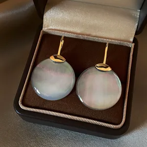 Dettaglio di madreperla grigio-blu iridescente e ganci dorati, nella custodia marrone in velluto