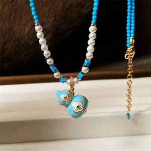 Collana con ciondoli a forma di zucca in smalto blu, perline blu, perle bianche e dettagli dorati