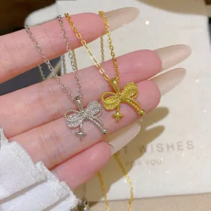 Close-up of silver and gold bow pendants with glittering details and star charms on fine chains