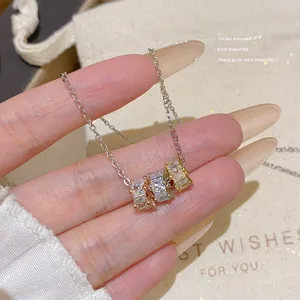 Close-up of three square-cut zircon stones in rose gold, silver and champagne-tone settings