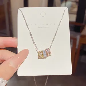 Silver-tone necklace displayed on a white card, with three square zircon pendants in mixed hues
