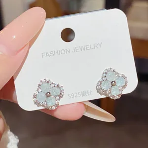 Close-up of pale blue flower stones and tiny clear accents on silver-tone studs displayed on a card
