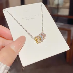 Close-up of a silver-tone chain and multicolor square zircon pendant displayed on a white card