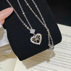 Close-up of a silver-tone heart pendant with sparkling clear stones and an openwork bow detail