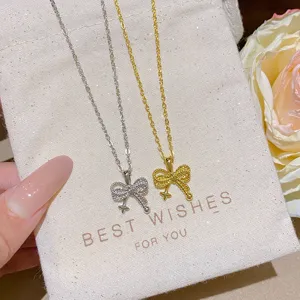 Close-up of silver and gold fine-chain necklaces with sparkling bow pendants and tiny star charms