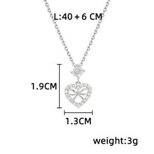 Silver-tone heart pendant with a bow and clear stones, shown with chain and pendant measurements