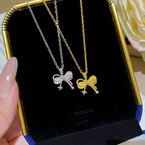 Close-up of silver and gold bow pendants with sparkling stones and tiny star charms on fine chains