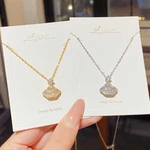 Two fan-shaped crystal pendants in gold and silver finishes displayed on white jewelry cards