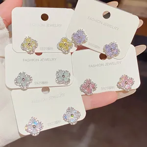 Close-up of five floral stud earring pairs with colorful cubic zirconia displayed on white cards