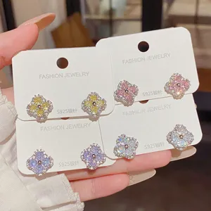Four pairs of sparkling clover studs in yellow, pink, purple and white, displayed on cards