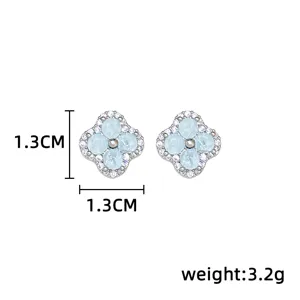 Front view of blue four-petal studs with silver-tone borders and clear stones, 1.3 cm wide