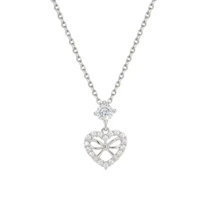 Silver-tone necklace with a crystal-set heart bow pendant and round accent stone, shown on white