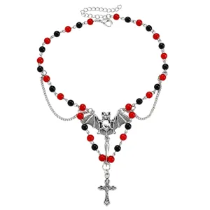 Collana distesa con perline rosse e nere e ciondoli argentati a forma di pipistrello e croce