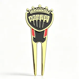 Front view of a gold-tone golf repair fork with a crown and playing-card emblem, red accents