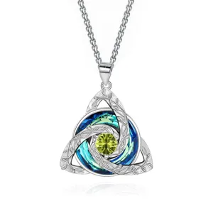 Close-up of silver Celtic knot pendant with a lime-green center gem and blue-green stones