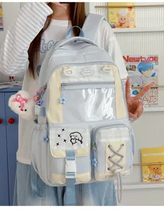 Worn on a model, the backpack has a clear front window, zip pockets, and star and bear charms.