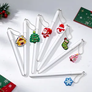 Overhead view of white pens with beaded chains and colorful Christmas charms arranged in a fan