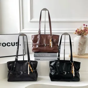 Große Schultertaschen aus Kunstleder in Braun und Schwarz, zusammen mit Gürteldetails präsentiert