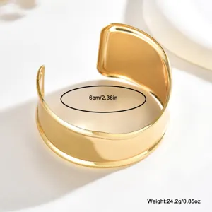 Dettaglio di un bracciale aperto dorato lucido con bordi rialzati, misura 6 cm e peso 24,2 g