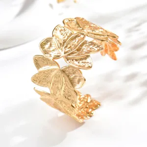 Primo piano del bracciale dorato a foglie, con venature in rilievo e riflessi metallici lucidi